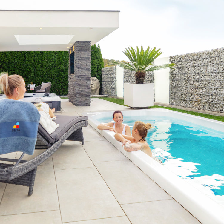 two women in swim spa talking with one woman besides