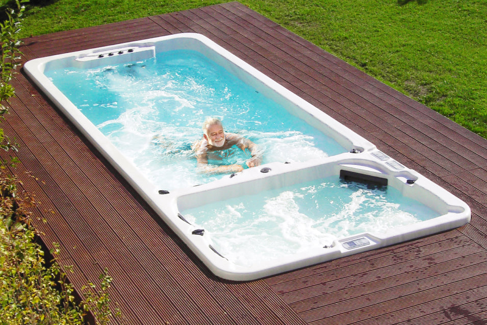 an old man swimming in dual chamber swim spa